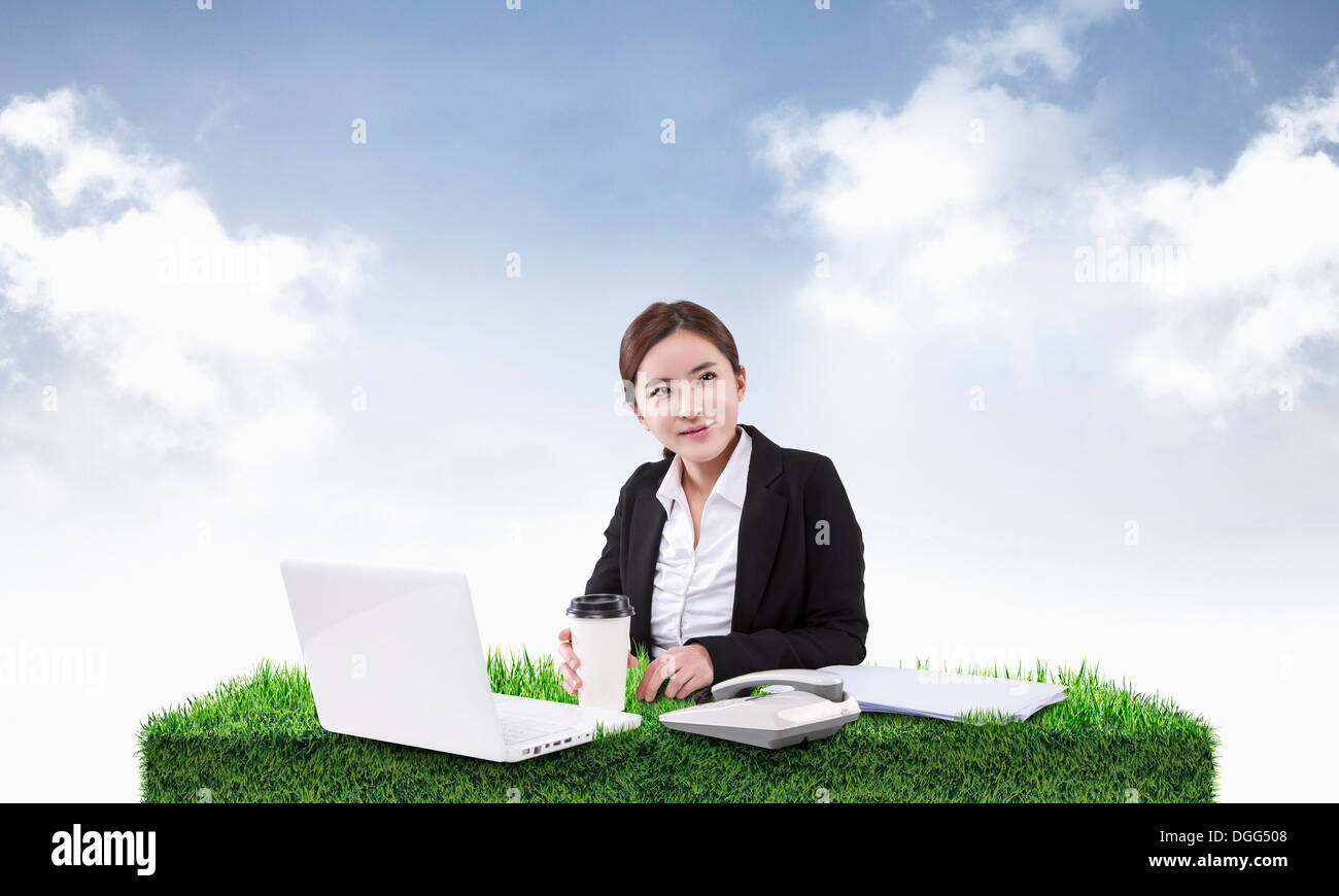 a woman working on a desk of grass Stock Photo