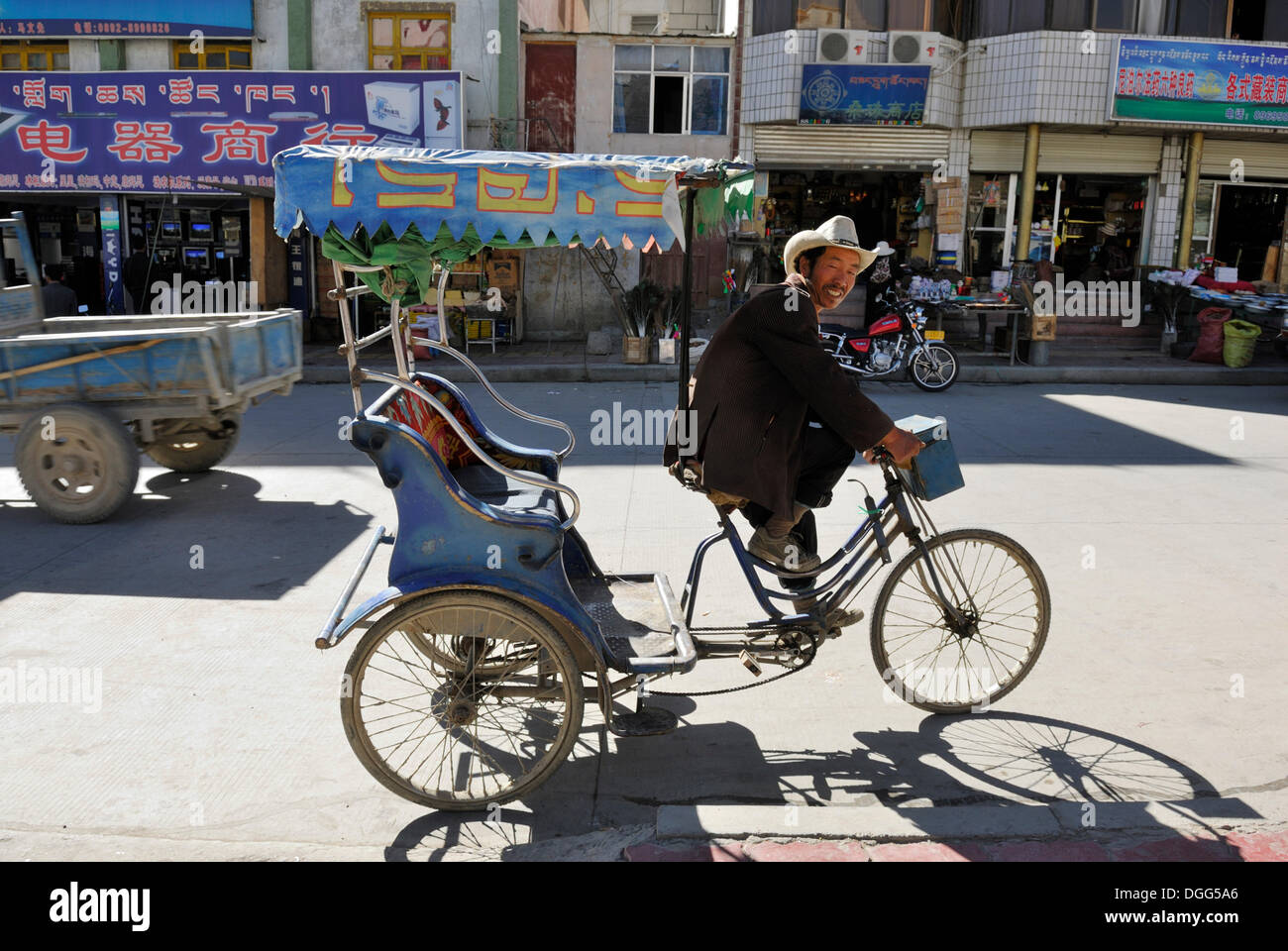 Rickshaw driver in the historic town centre of Shigatse, Tibet, China ...