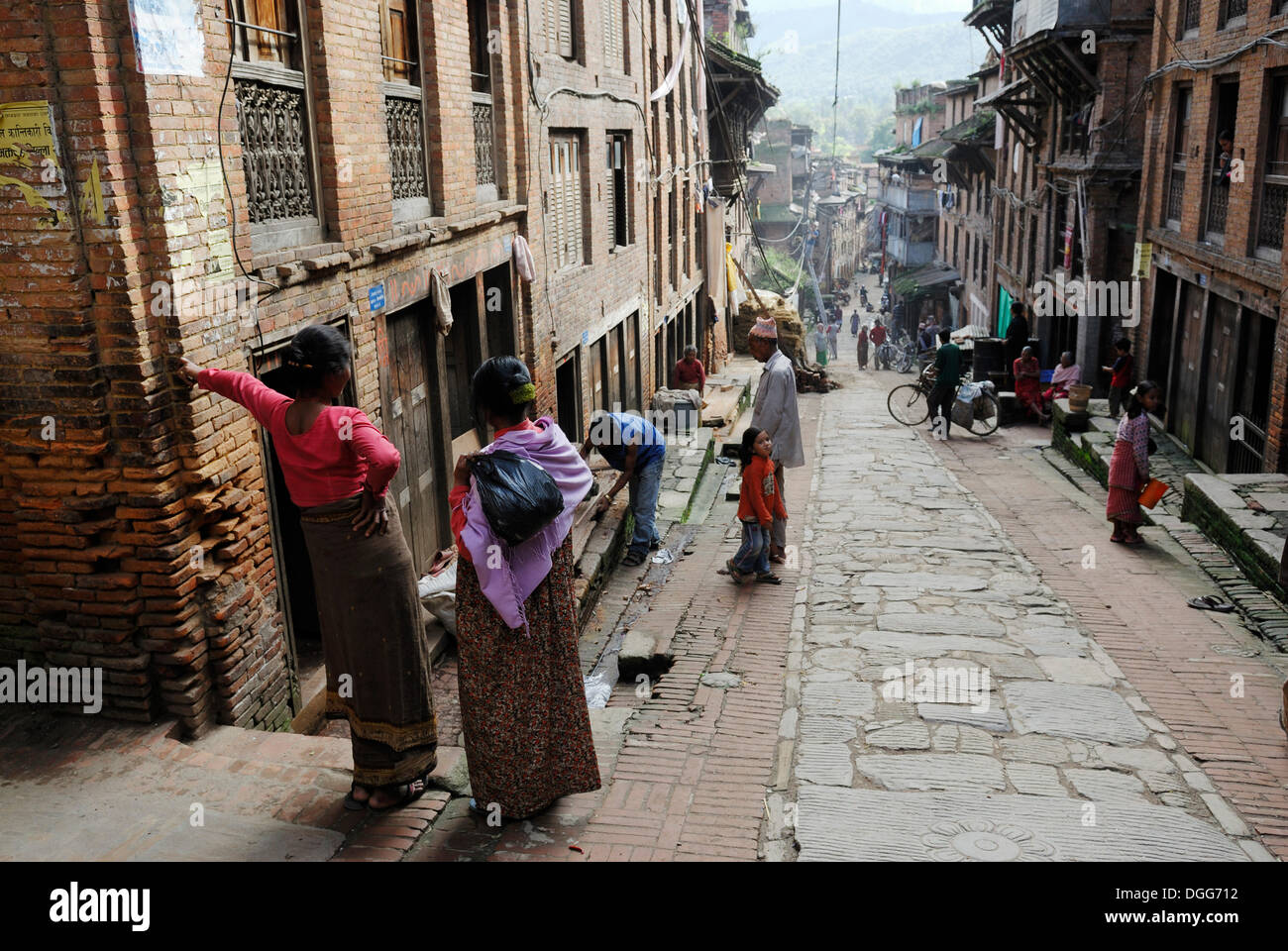 Nepalese people in traditional dress on historic street, Bhaktapur, Kathmandu Valley, Nepal, Asia Stock Photo