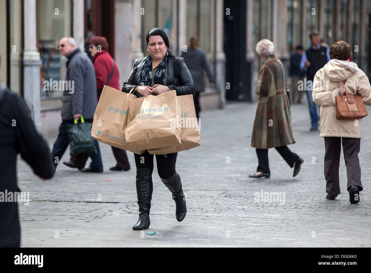 A woman shopper walks through Liverpool City Centre carrying Primark shopping bags Stock Photo