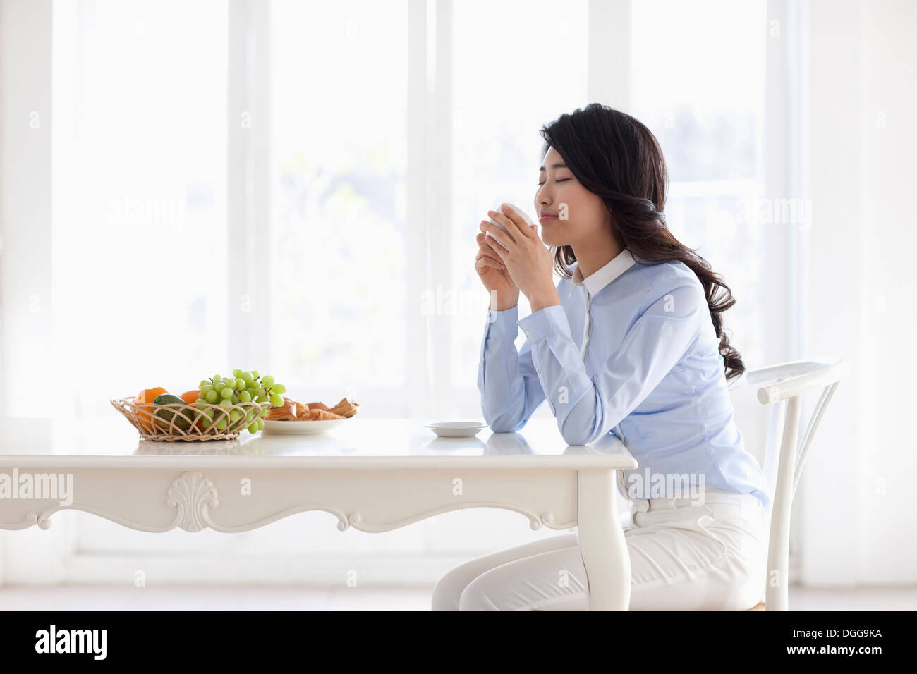 a young woman eating breakfast and working Stock Photo