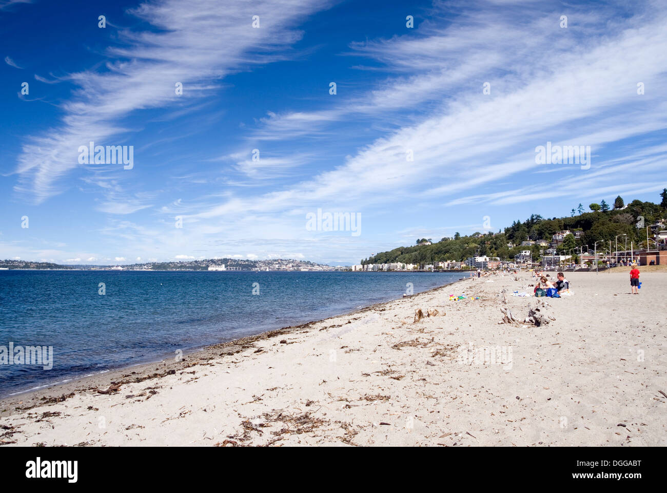 Family at play in the sand at Alki beach, and the view of Seattle across Elliott Bay, Alki, West Seattle, USA Stock Photo