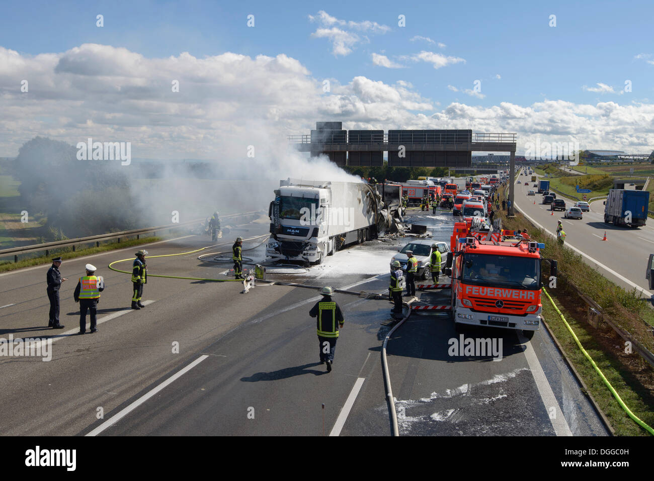 Firefighters extinguishing a truck fire on the A8 motorway near the 'Echterdinger Ei' junction, Stuttgart, Baden-Wuerttemberg Stock Photo