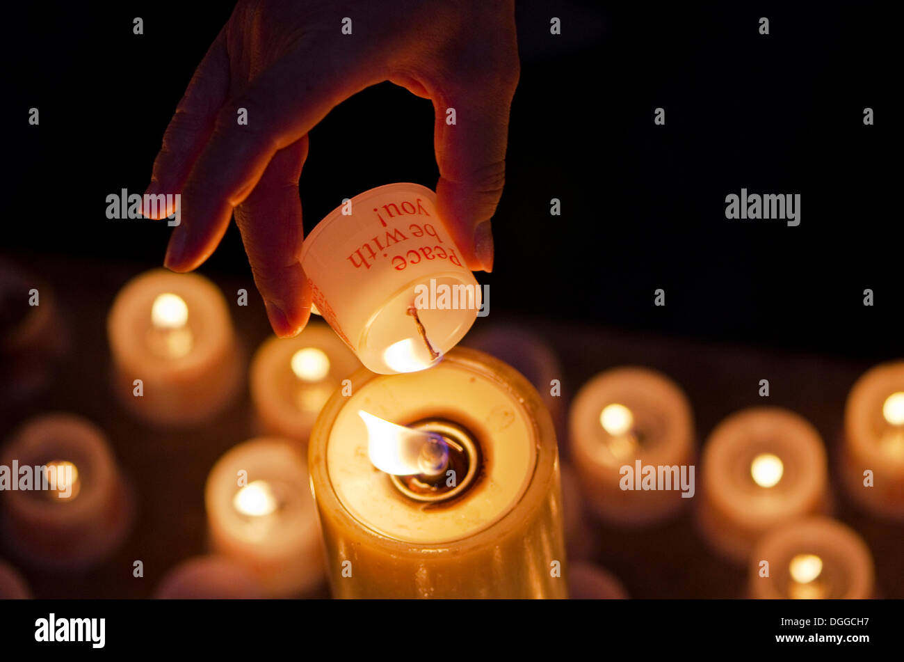 Hand of a devotee lightening a candle for offering inside the Frauenkirche church, Dresden, Saxony Stock Photo
