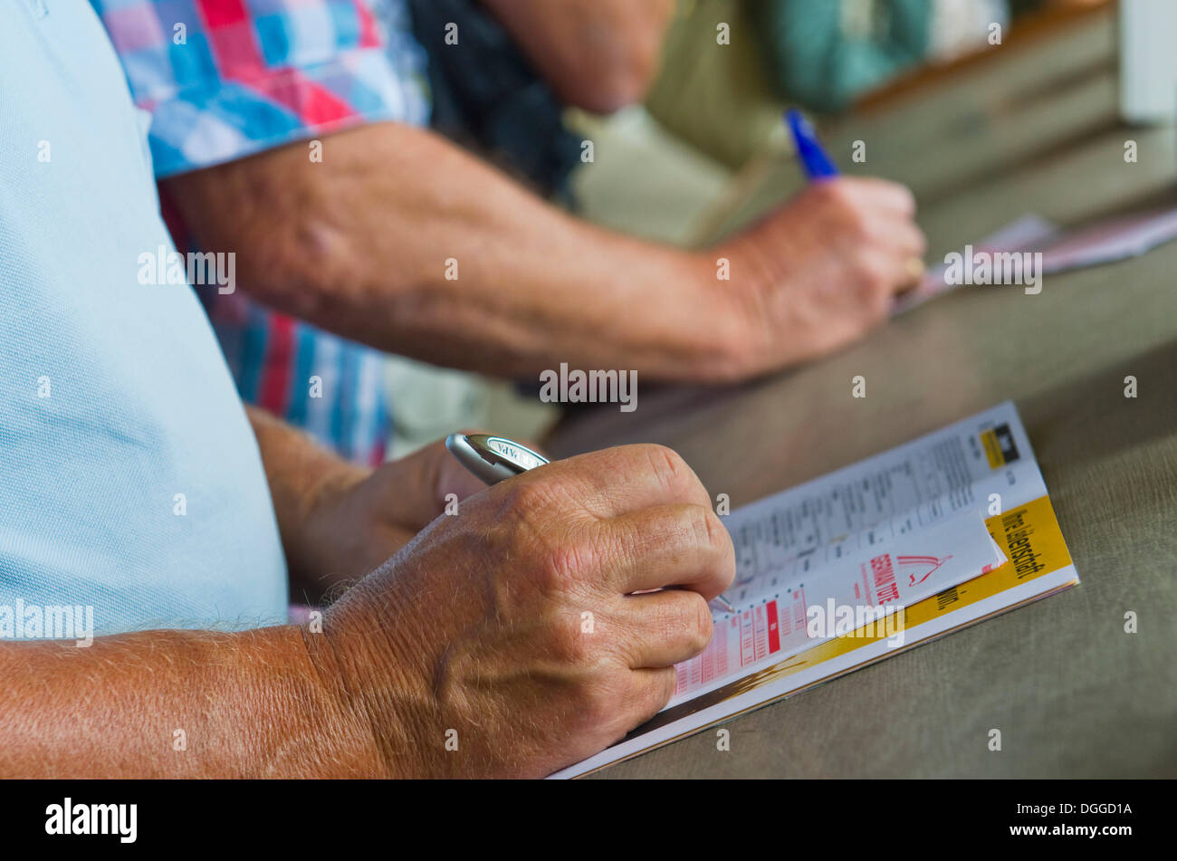 People placing a bet just before a horse race, Dresden, Saxony Stock Photo