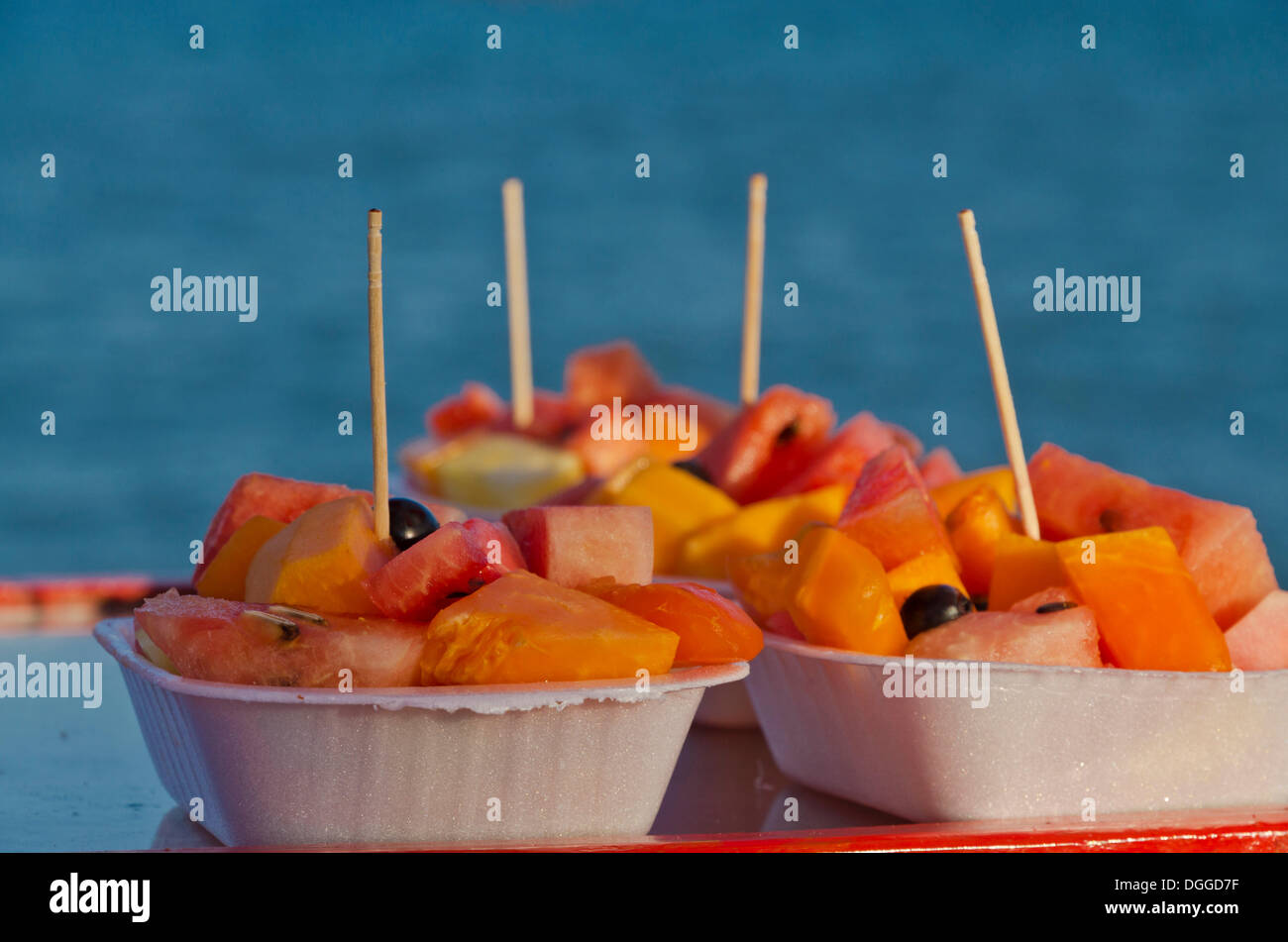 Little containers filled with fruit for sale at the beach of