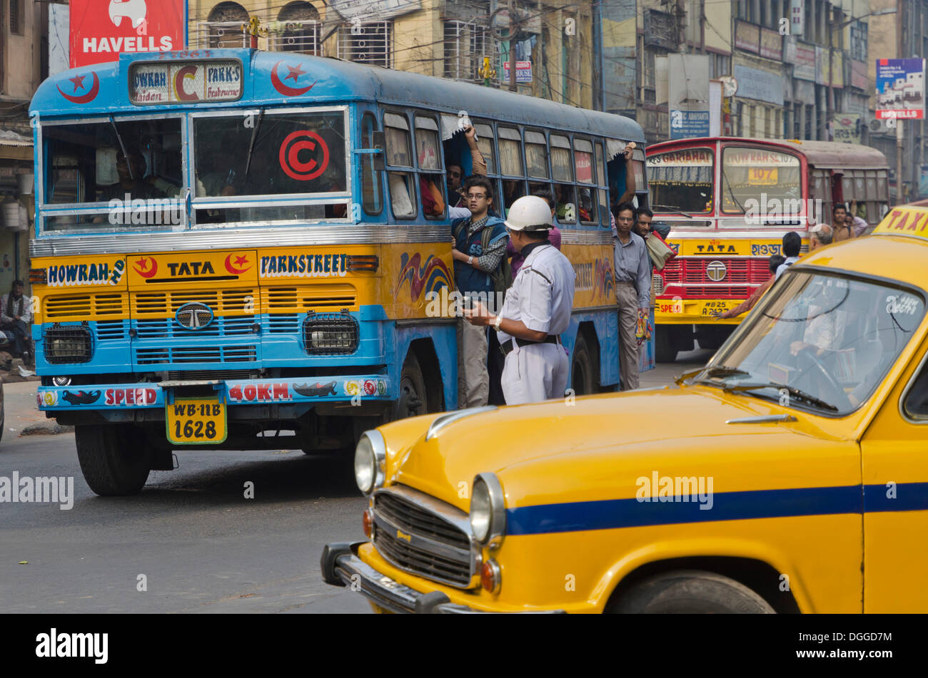 Street scene with public bus, taxi and policeman, Kolkata, India, Asia Stock Photo