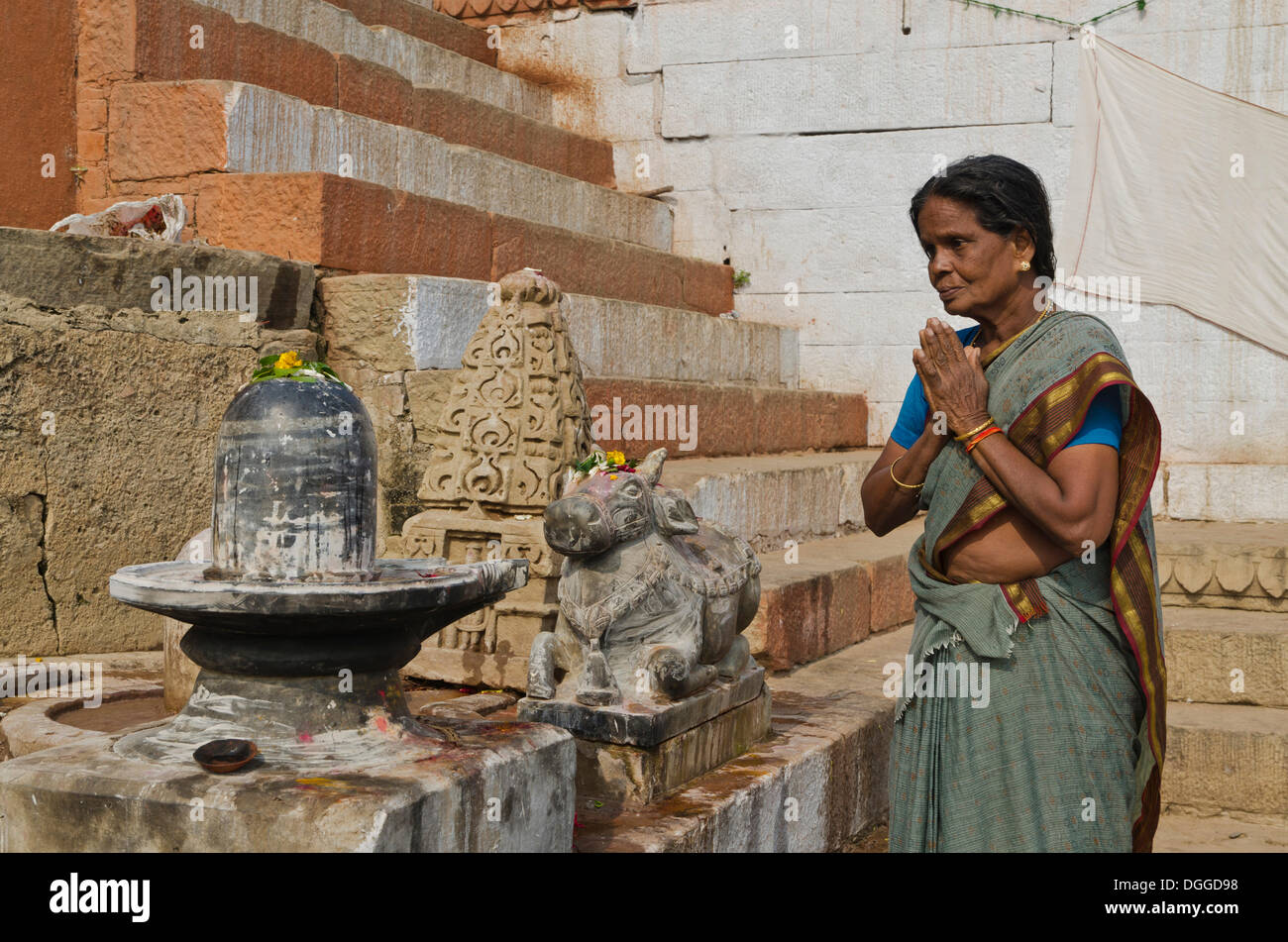 Woman praying to a Shiva Lingam, at the ghats of Varanasi, India, Asia Stock Photo