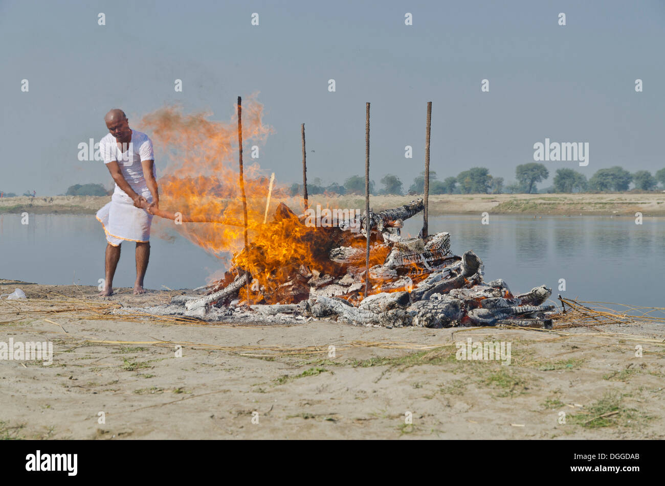 The eldest son maintaining the fire as part of a cremation ceremony, Vrindavan, India, Asia Stock Photo