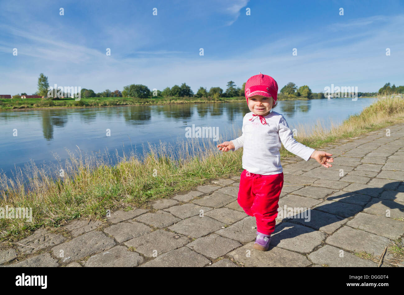 Little girl, 14 months, doing her first steps on a footpath on a riverbank along the Elbe river, Dresden, Saxony Stock Photo