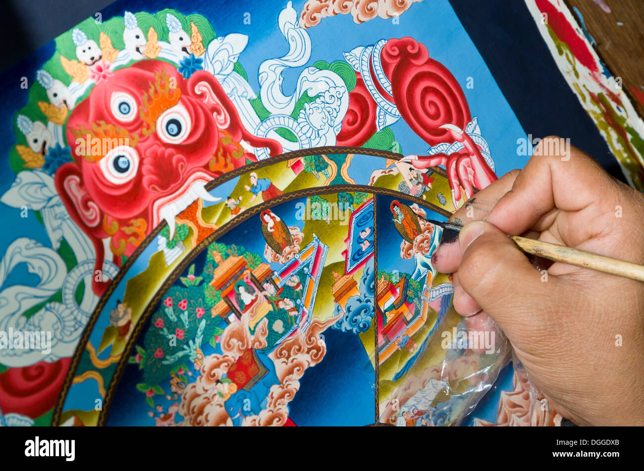 Artist painting a colourful Thangka in an art school, Kathmandu Valley