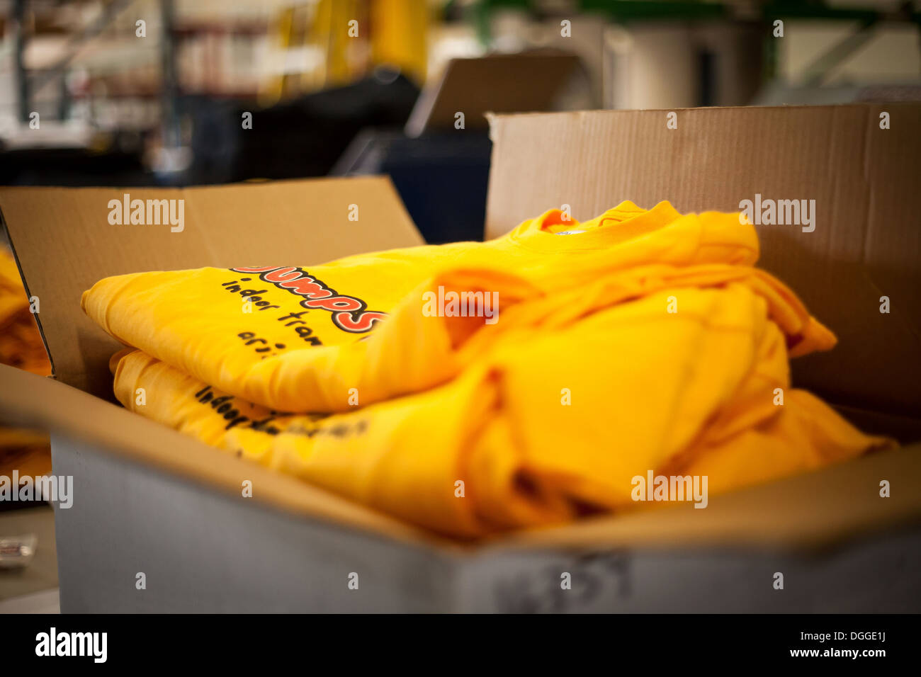 Open cardboard box containing screen printed t-shirts Stock Photo