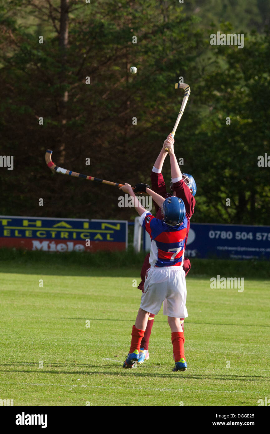 Two young shinty players battle it out using their caman. Stock Photo