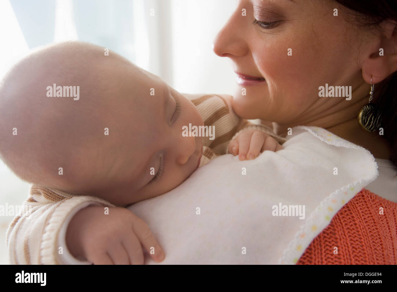 Baby boy sleeping on mother's shoulder, close up Stock Photo