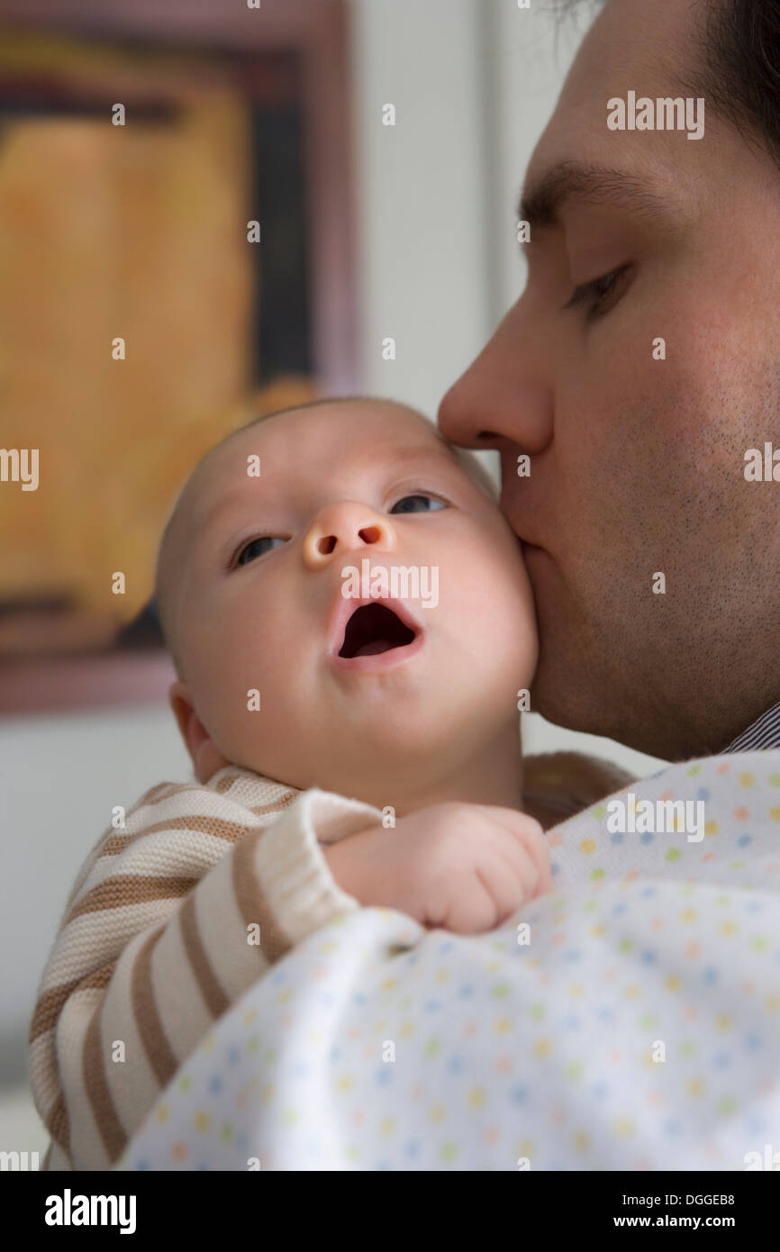 Mid adult father kissing baby boy Stock Photo