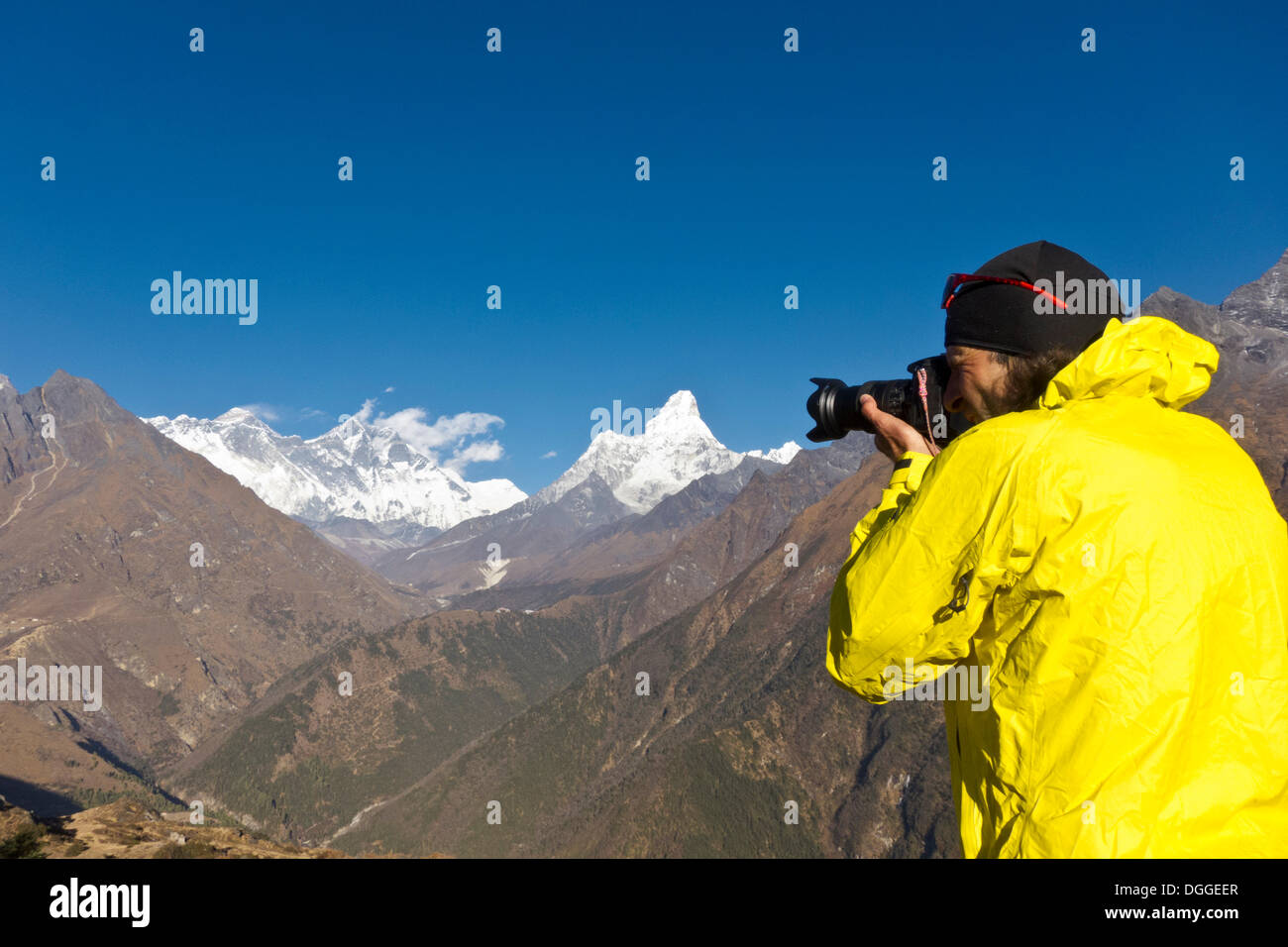 Photographer with yellow jacket taking a photograph of Mount Everest
