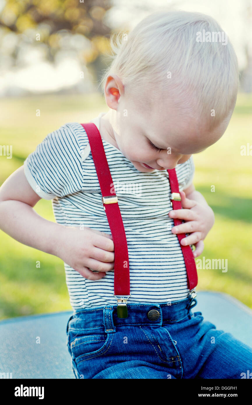 Young boy looking at trousers braces Stock Photo - Alamy