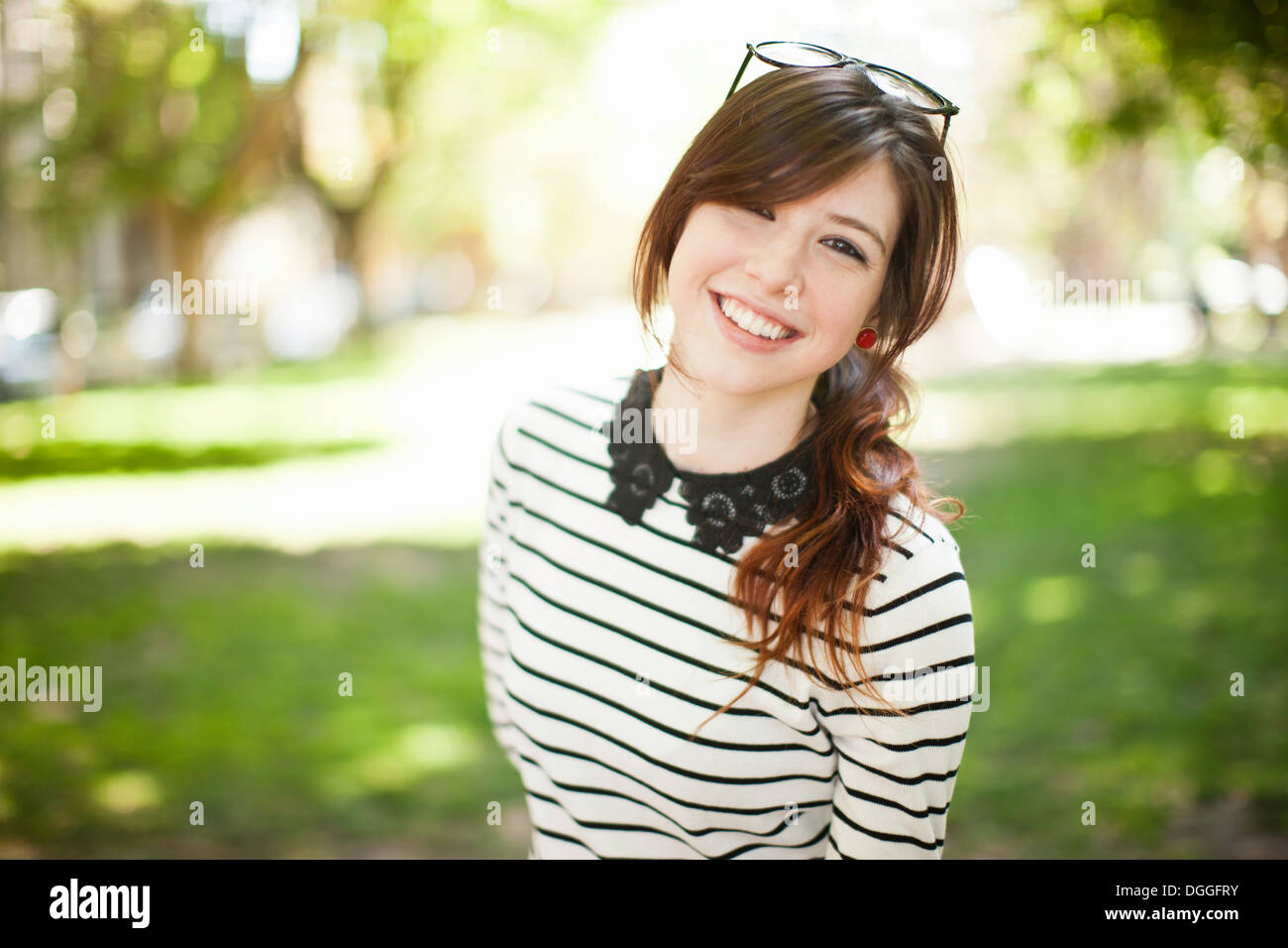 Portrait of young woman in park Stock Photo - Alamy