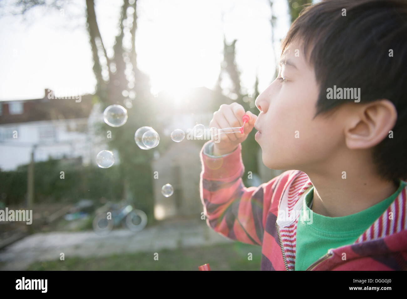 Boy blowing bubbles with wand, close up Stock Photo