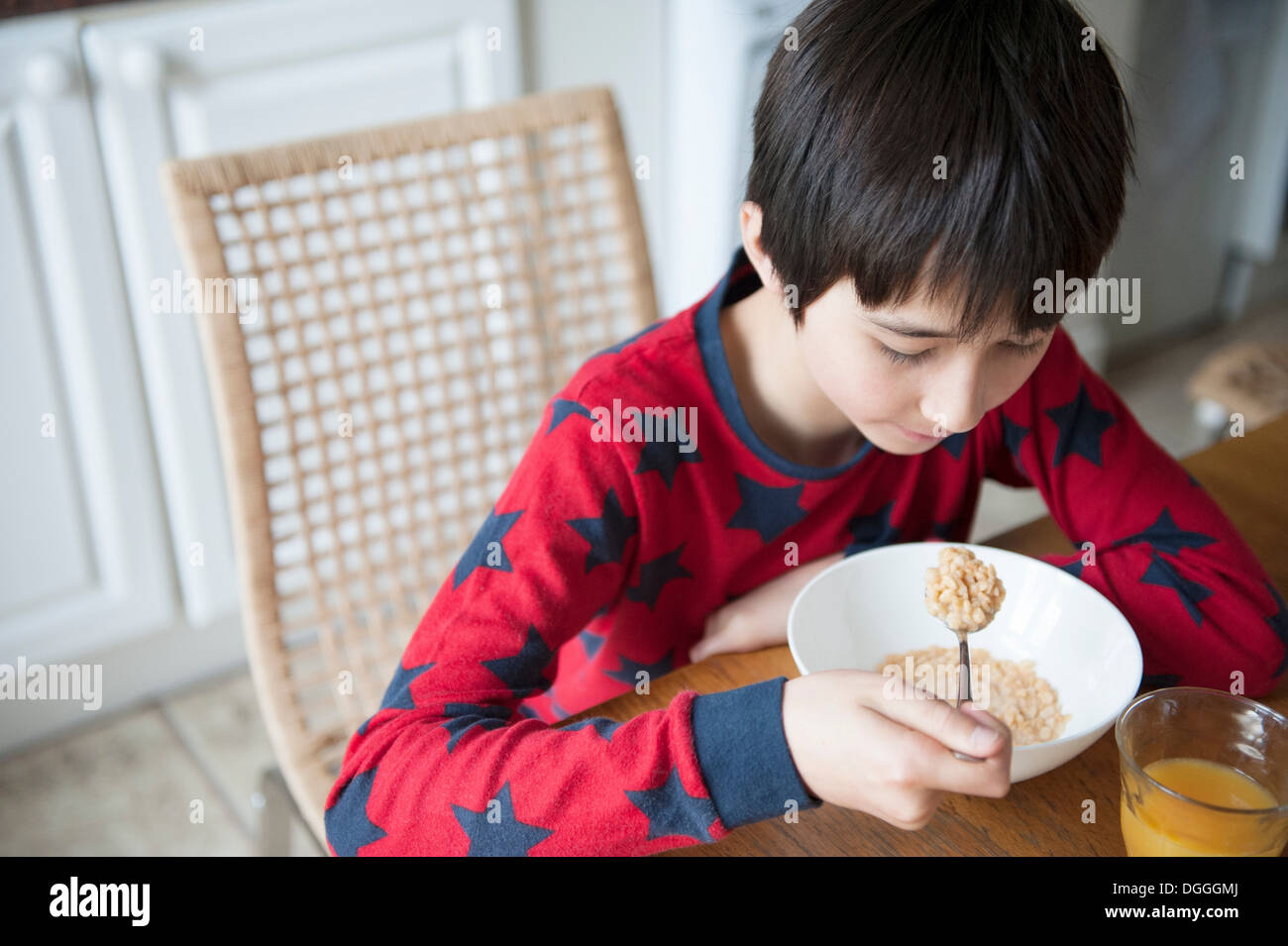 Boy eating breakfast cereal at table Stock Photo