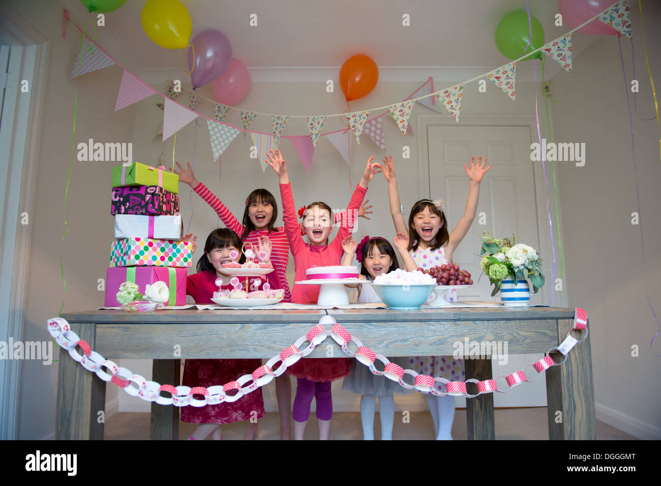 Girls cheering at birthday party Stock Photo