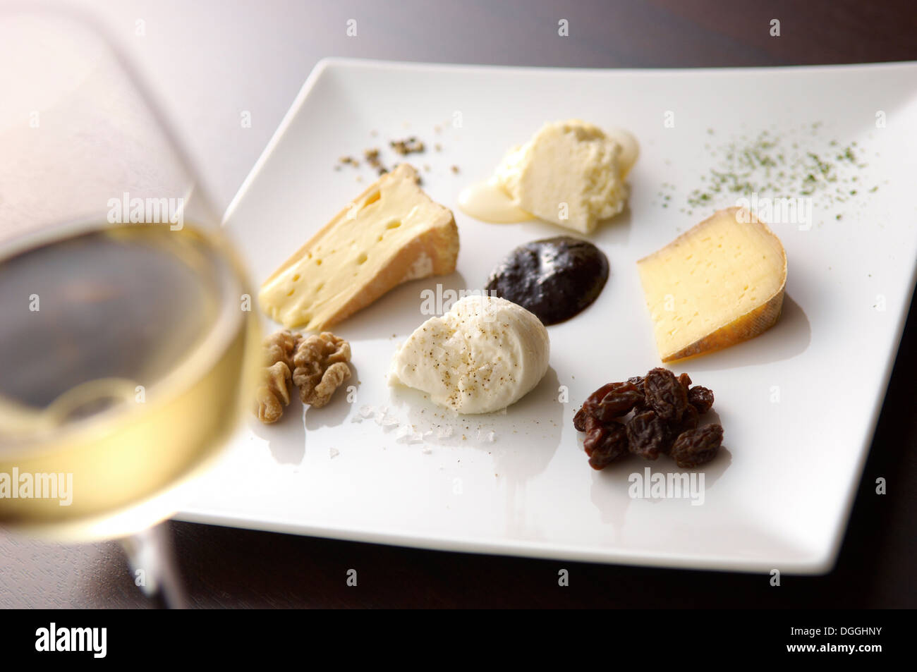 Still life with white wine and selection of cheeses Stock Photo - Alamy