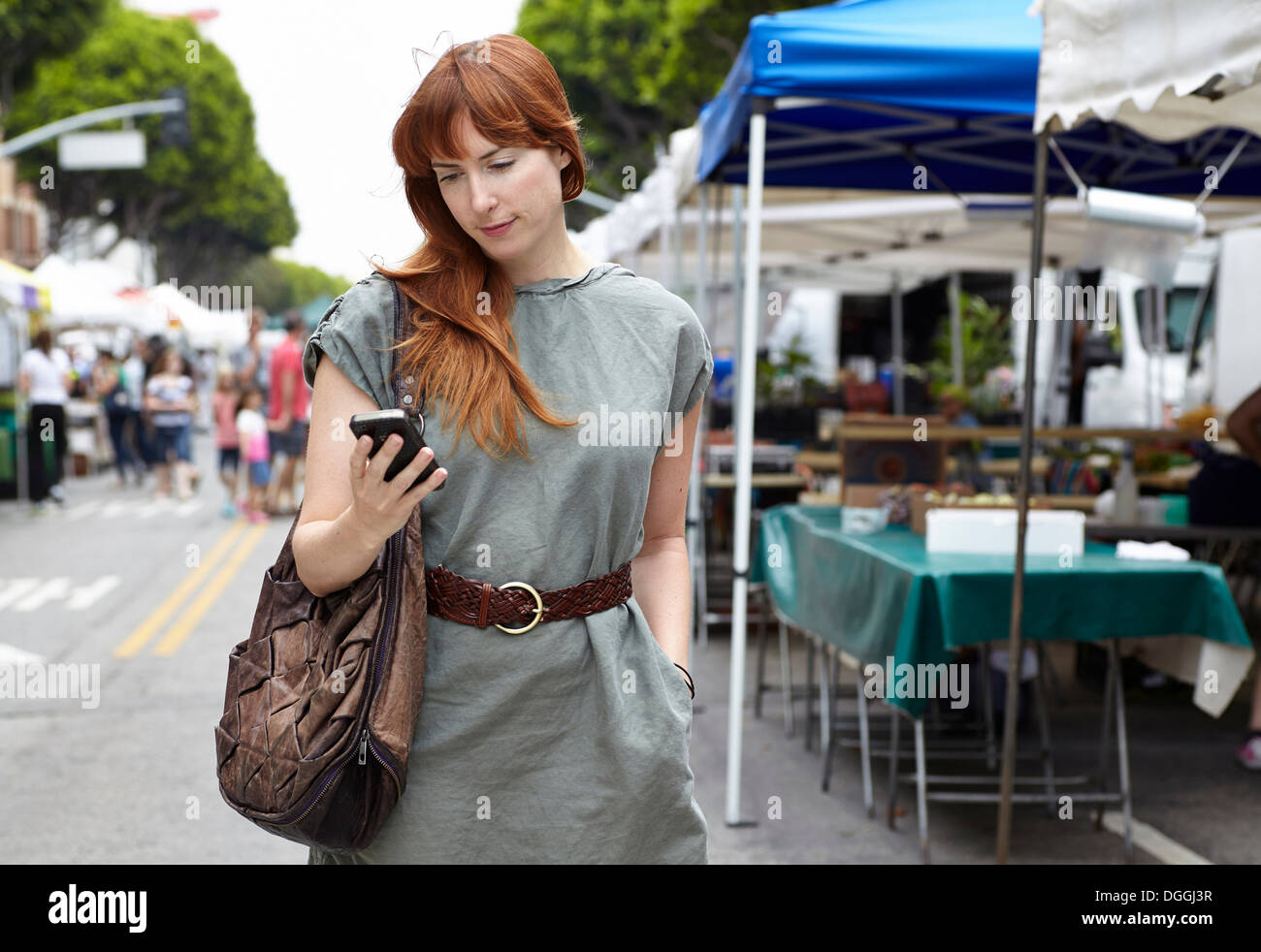 Mid adult woman looking at mobile phone in city Stock Photo