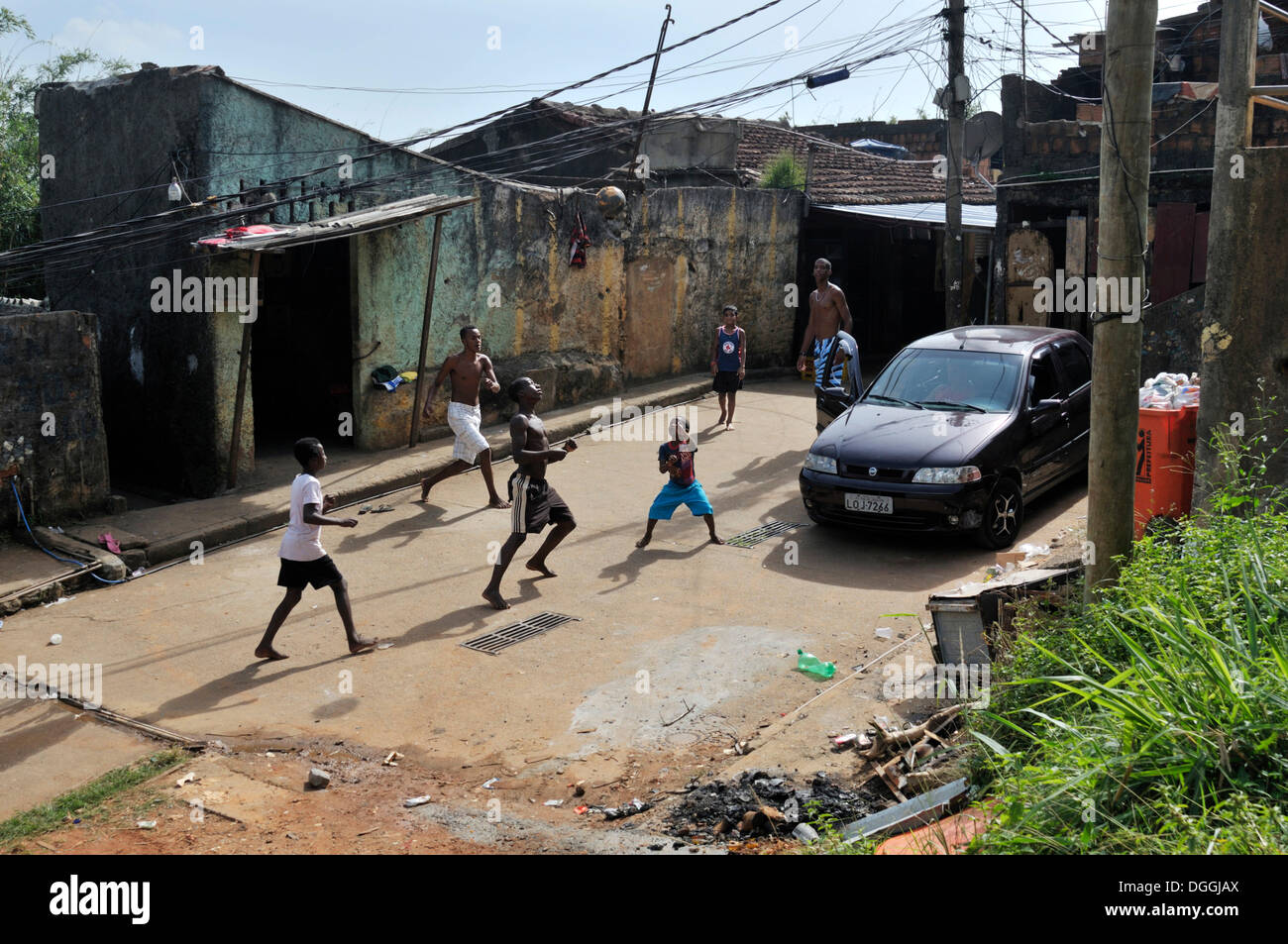 Youths playing football in the street, slum district of Favela Morro da Formiga, Tijuca district, Rio de Janeiro, Brazil Stock Photo