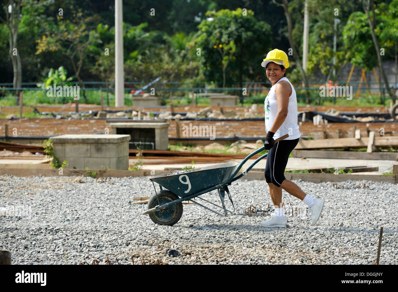 Woman pushing a wheelbarrow on a building site of the "Esperanca ...