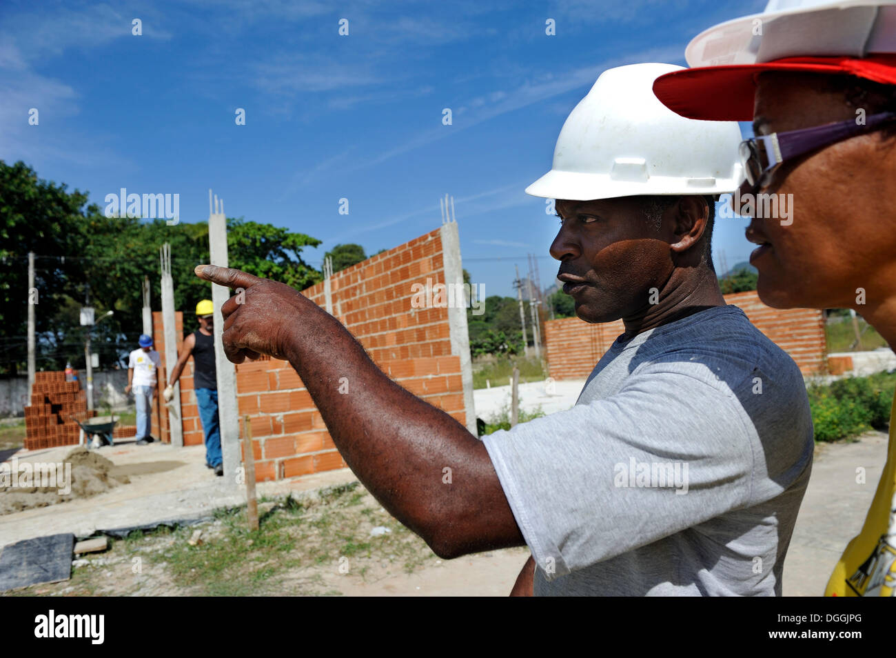 Construction supervisor and the president of the 'Esperanca' housing co-operative inspecting the building site, each family Stock Photo