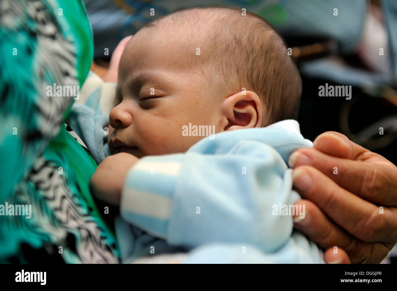 Baby sleeping peacefully on his mother's lap, Rio de Janeiro, Brazil