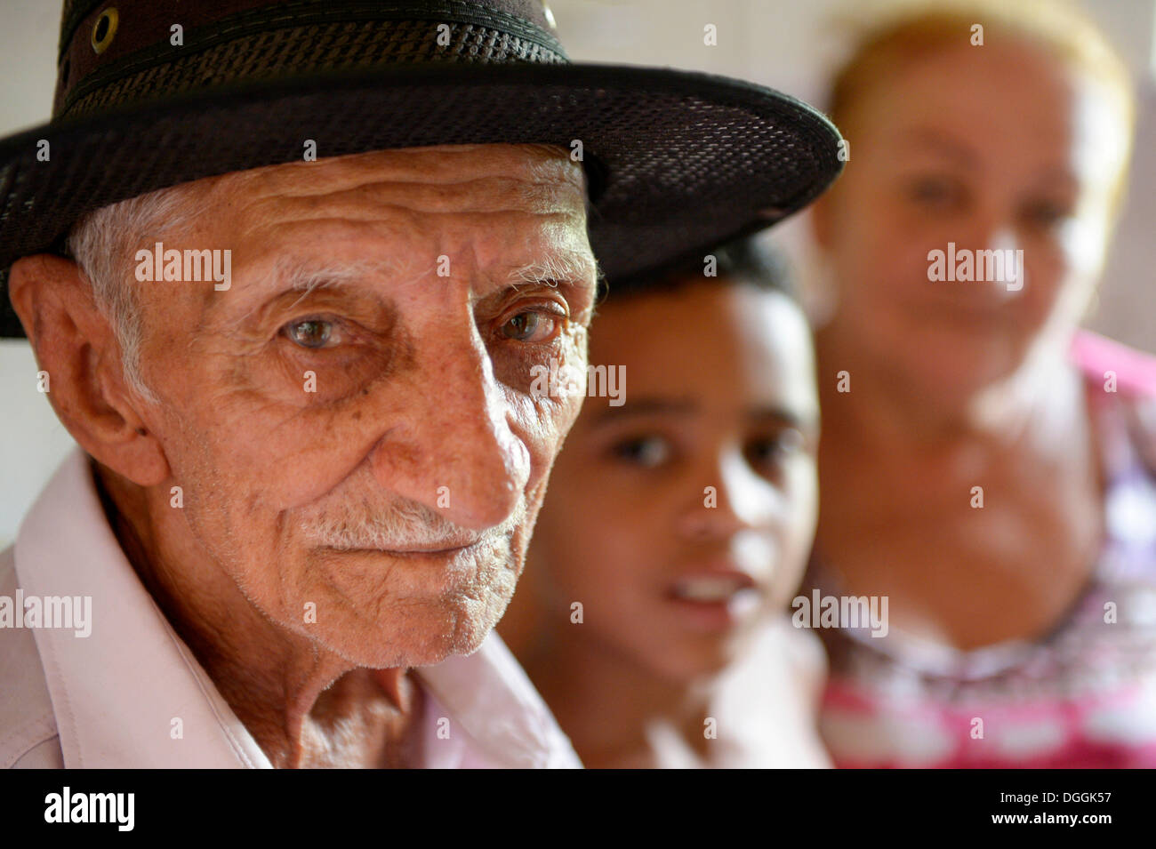 Elderly man, portrait, his grandson, 2 years, and his wife at back, Poxoréo, Mato Grosso, Brazil Stock Photo