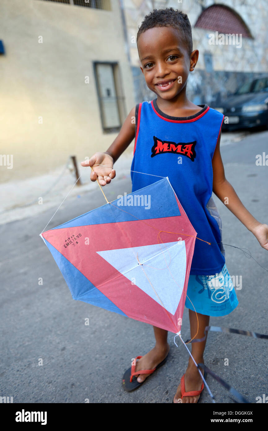 Young boy holding a kite in a slum or favela, Jacarezinho favela, Rio de Janeiro, Rio de Janeiro State, Brazil Stock Photo