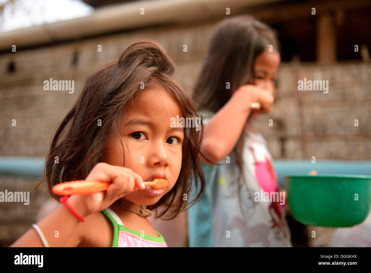 Two girls brushing their teeth outside a house, hygiene education, Lompong Commune, Bathi District, Takéo Province, Cambodia Stock Photo