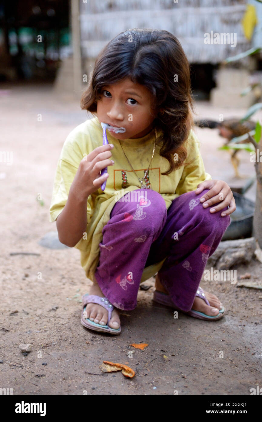 Girl brushing her teeth outside a house, Lompong Commune, Bathi District, Takéo Province, Cambodia Stock Photo