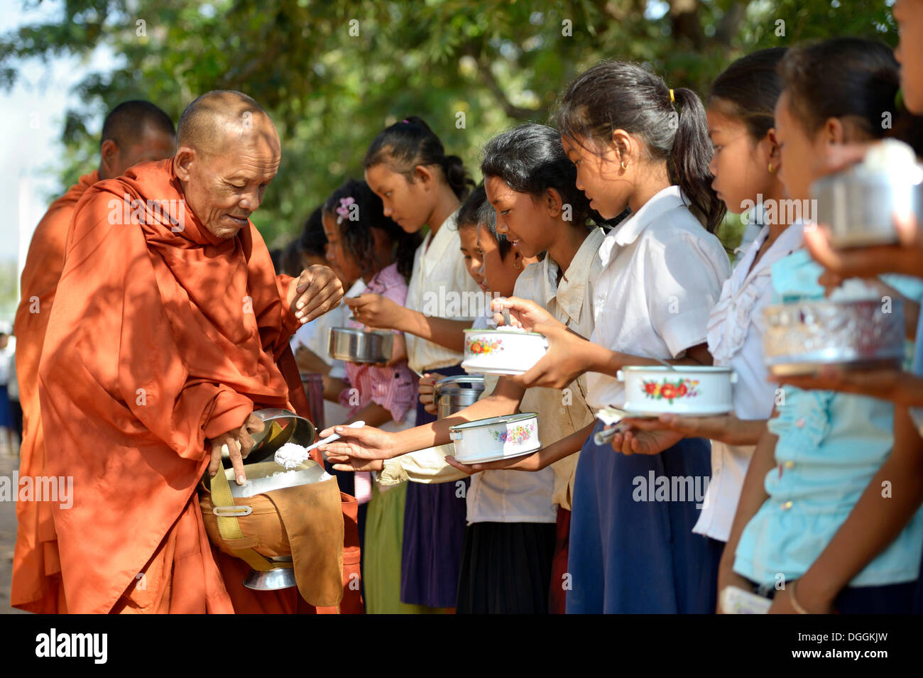 Children donating food and money to a Buddhist monk, traditional ceremony as part of the celebration of the Cambodian New Year Stock Photo