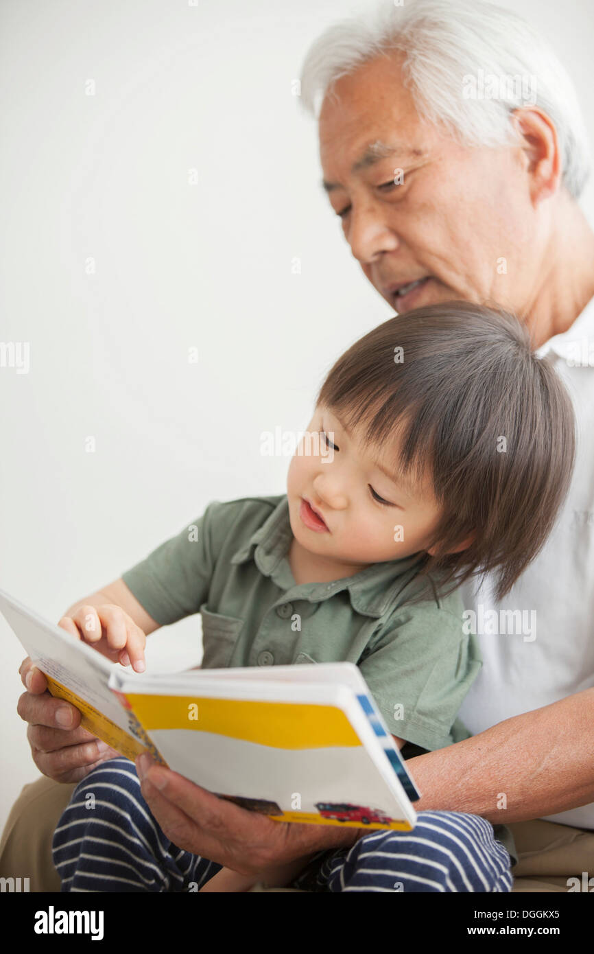 Grandfather reading to grandson Stock Photo
