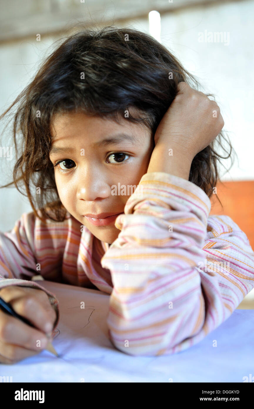 Schoolgirl writing in a notebook, in the community of Mbya-Guarani Indians, Campito, Caaguazú Department, Paraguay Stock Photo