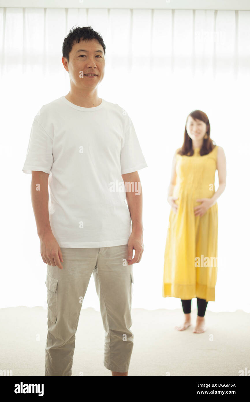 Man with pregnant woman in background, portrait Stock Photo - Alamy