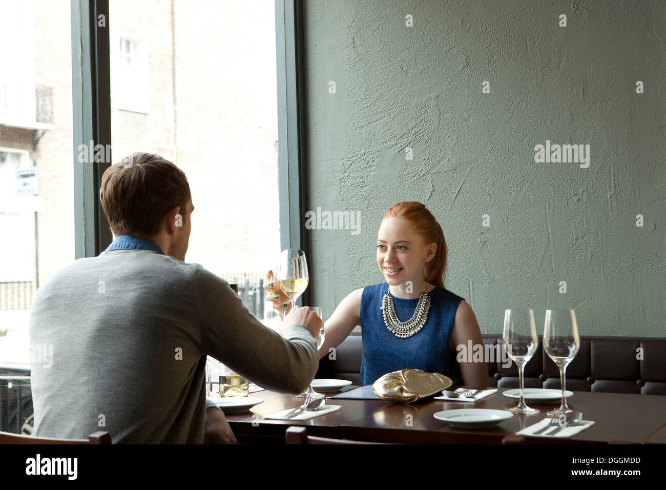 Young couple in restaurant toasting wine glasses Stock Photo