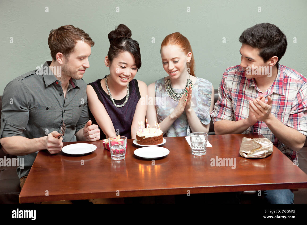 Four friends celebrating birthday in restaurant Stock Photo