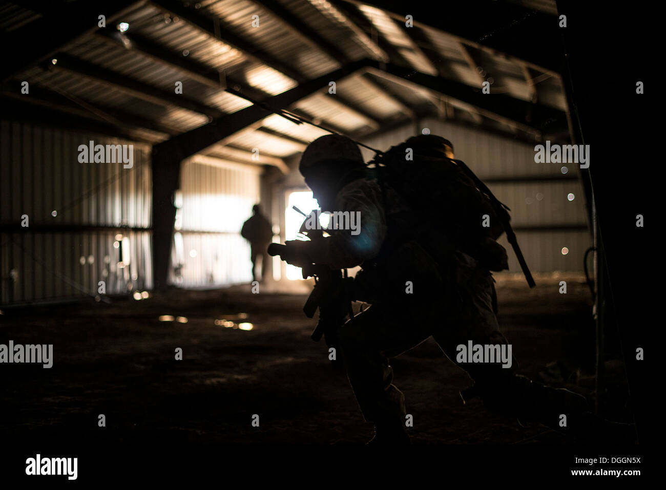 U.S. Marine Cpl. Daniel Soto, 1st Air Naval Gunfire Liaison Company forward air controller deployed from Camp Pendleton, Calif., calls his four-man team to exit a cleared building during exercise Mountain Roundup 2013 at Juniper Butte Range, about 70 mile Stock Photo