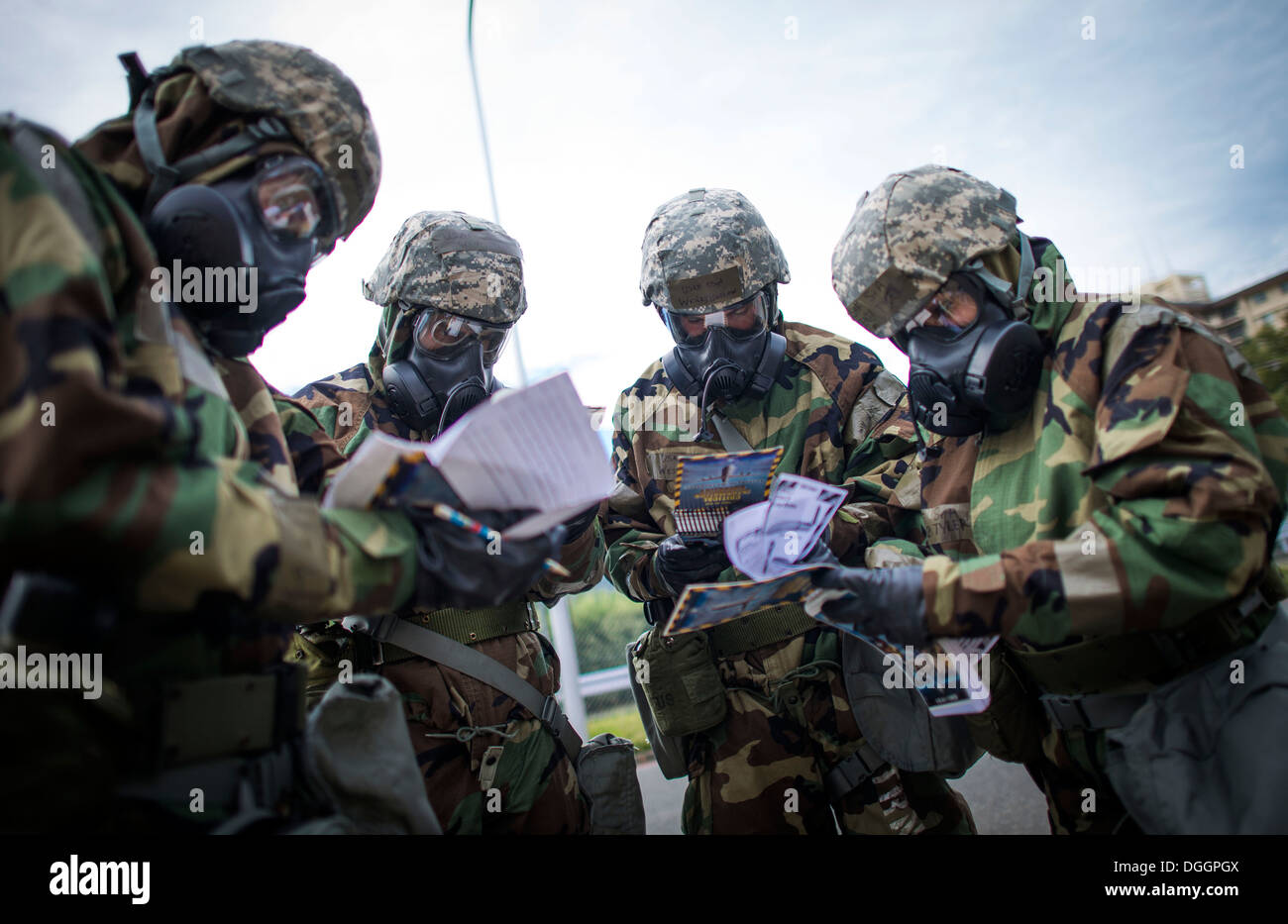 374th Medical Group personnel verify an unexploded ordnance description during ability to survive and operate (ATSO) training Oct. 9, 2013 at Yokota Air Base, Japan. ATSO training was held to reacquaint Airmen with basic contingency skills. Stock Photo