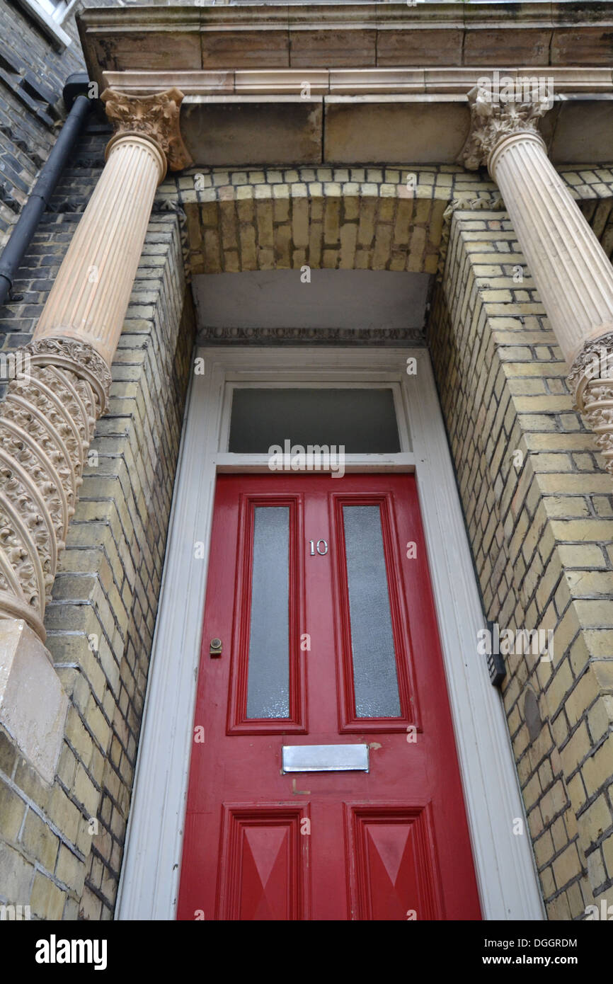 Red door with a brick frame. Stock Photo