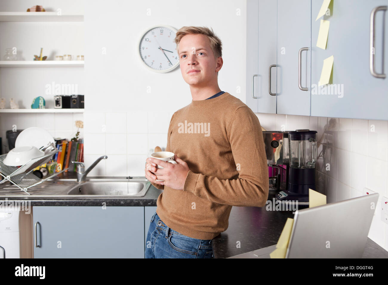 Young man in kitchen with coffee cup Stock Photo