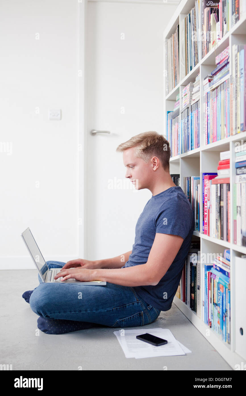 Young man sitting on floor using laptop Stock Photo