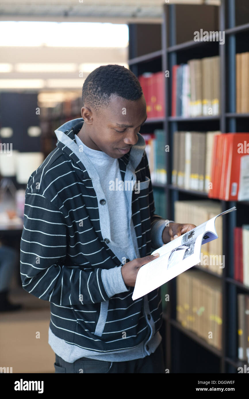 19 Year old male black college student researches articles in school library. Stock Photo
