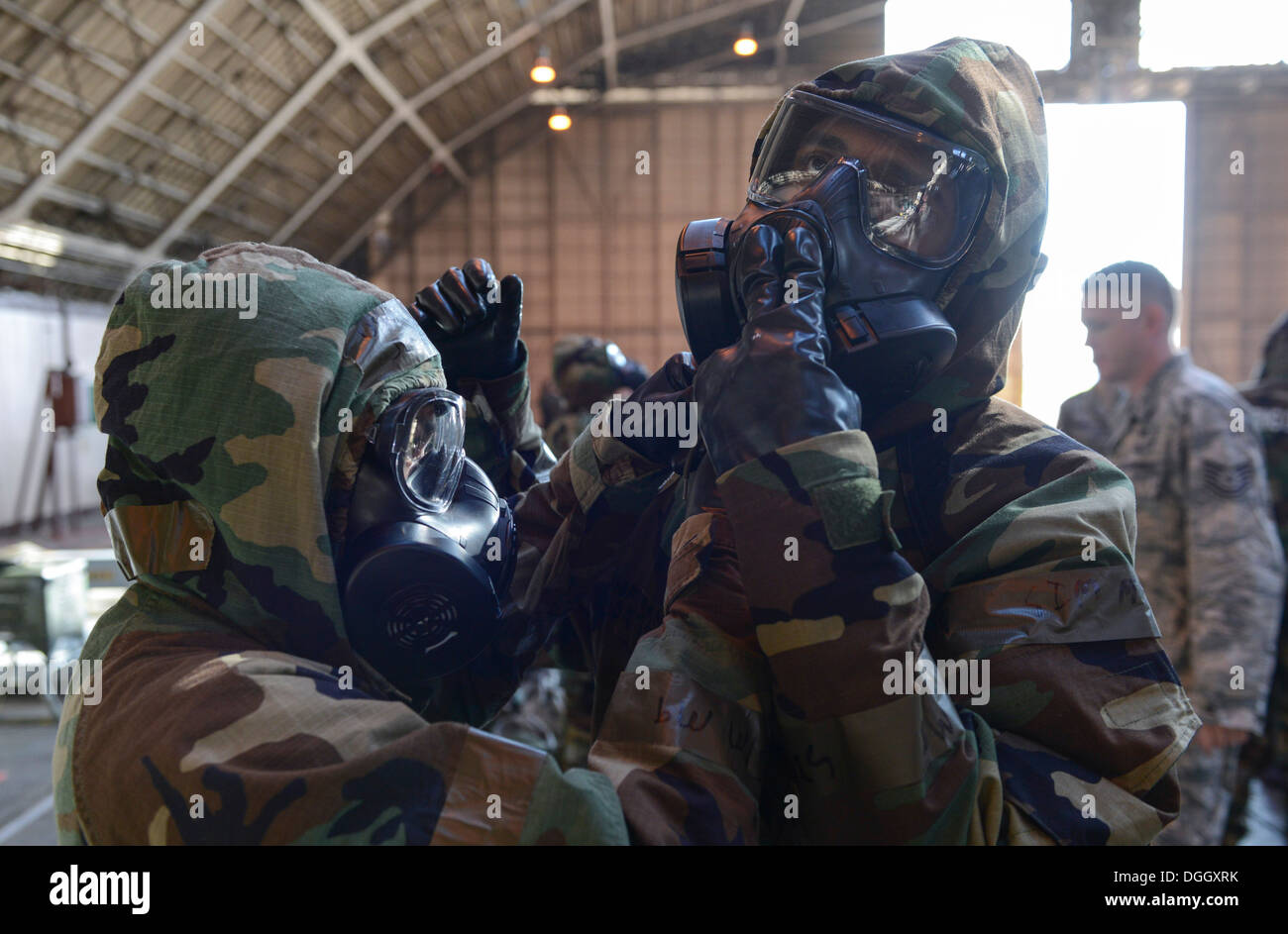 Two Airmen perform buddy checks on each other after donning their mission oriented protective posture gear during the ability to survive and operate rodeo at Yokota Air Base, Japan, Oct. 8, 2013. The purpose of the ATSO rodeo is for Airmen to hone their s Stock Photo