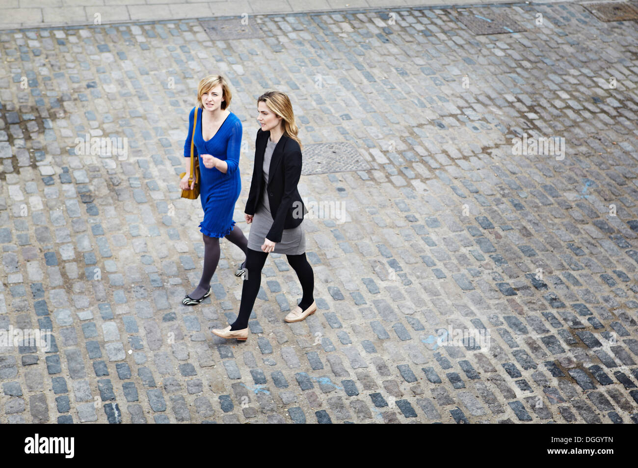 Businesswomen walking on cobbled street, high angle Stock Photo