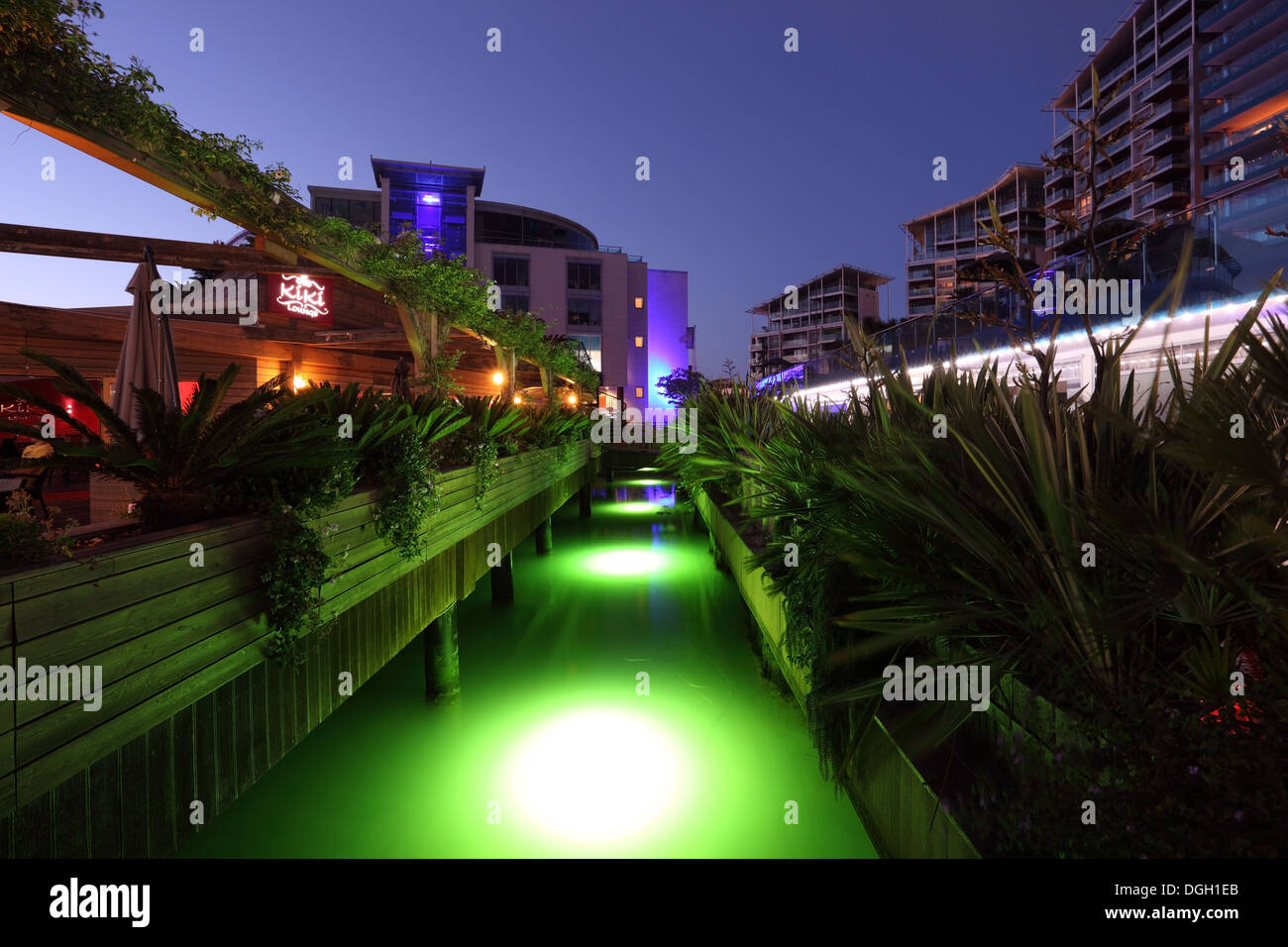 Green illuminated canal in Ocean Village Marina, Gibraltar Stock Photo